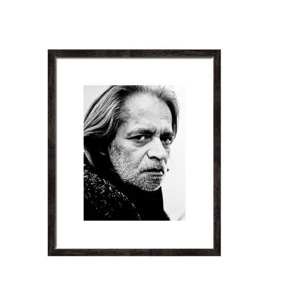 pngfile black framed ,black and white photograph of Meary James Thurairajah Tambimuttu (1915–1983) was a renowned poet, editor, and publisher who played a pivotal role in the London and New York literary scenes. Known by the pen name Tambimuttu or Tambi, he founded the influential magazine Poetry London in 1939. Photograph by Bo Lutoslawski modern brick wall interior and modern lamp;
