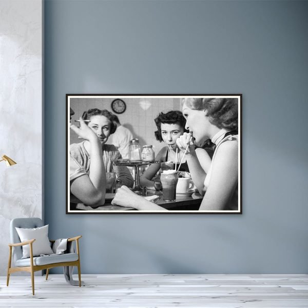 a black and white photograph of girls in a cafe